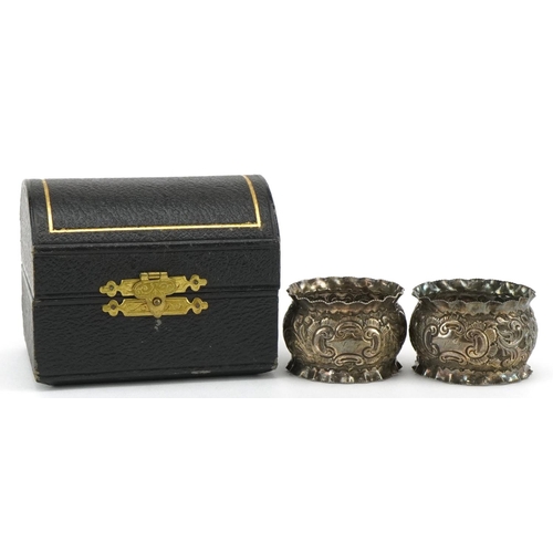 690 - J Sherwood & Sons, pair of Victorian silver napkin rings embossed with flowers and foliage, housed i... 