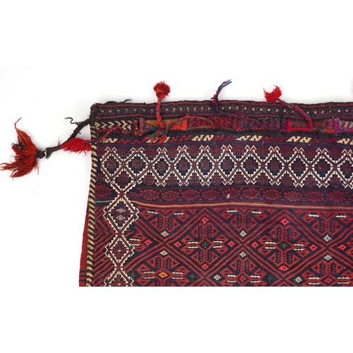 2207 - Rectangular Afghan red ground saddle bag having an allover repeat design, 150cm x 80cm