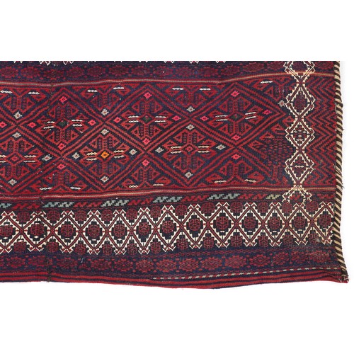 2207 - Rectangular Afghan red ground saddle bag having an allover repeat design, 150cm x 80cm