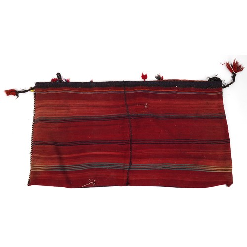 2207 - Rectangular Afghan red ground saddle bag having an allover repeat design, 150cm x 80cm