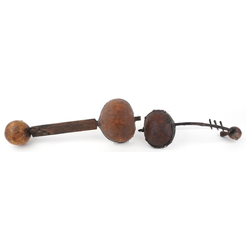 2356 - Two tribal interest African wooden animal hide musical instruments, the largest 68.5cm in length