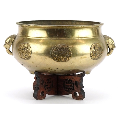 654 - Large Chinese bronze tripod censer with elephant head handles on hardwood stand with applied roundel... 