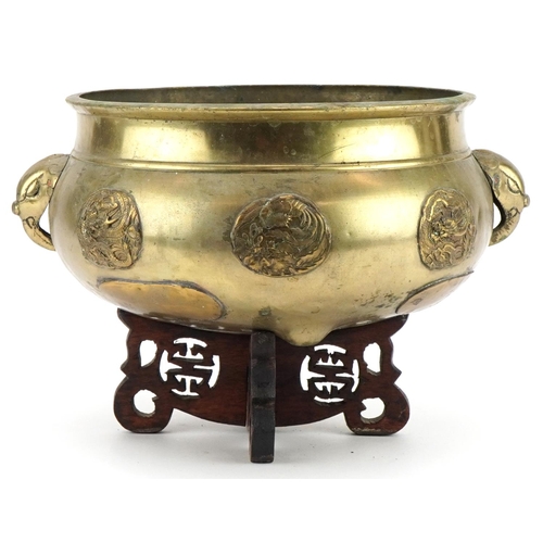 654 - Large Chinese bronze tripod censer with elephant head handles on hardwood stand with applied roundel... 