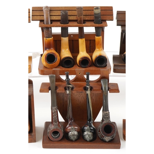 1281 - Twenty five vintage tobacco smoking pipes arranged in six pipe racks the pipes including block Meers... 