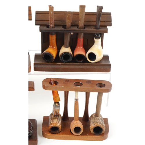 1281 - Twenty five vintage tobacco smoking pipes arranged in six pipe racks the pipes including block Meers... 