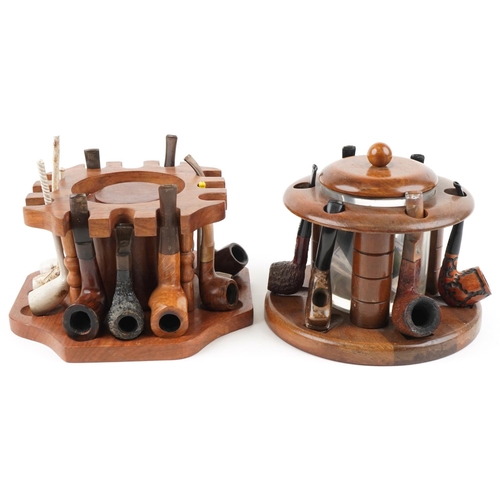 1321 - Twenty four vintage tobacco smoking pipes arranged in three pipe racks with tobacco boxes, some clay... 