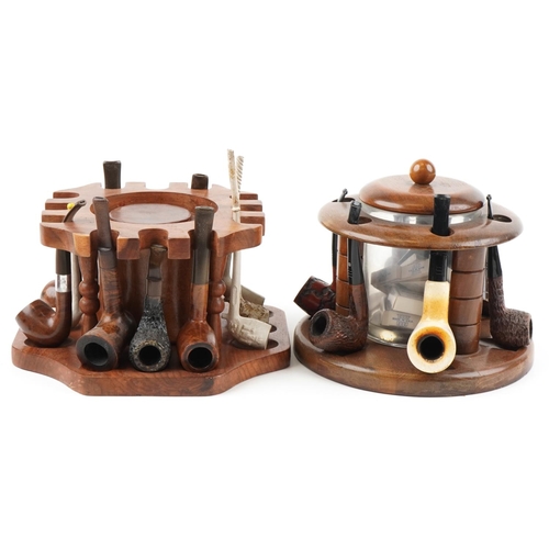 1321 - Twenty four vintage tobacco smoking pipes arranged in three pipe racks with tobacco boxes, some clay... 