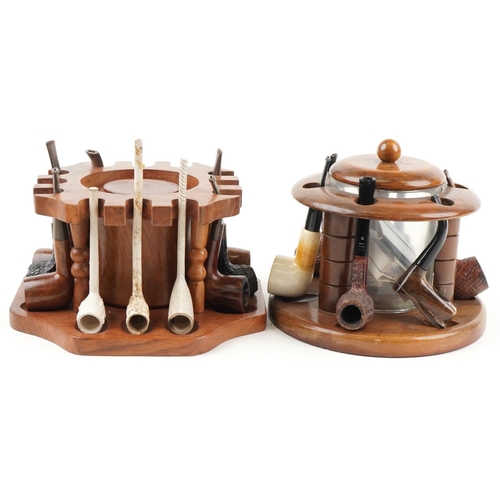 1321 - Twenty four vintage tobacco smoking pipes arranged in three pipe racks with tobacco boxes, some clay... 