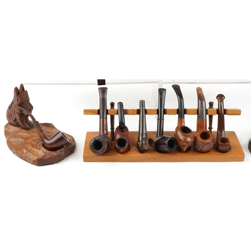 1272 - Twenty vintage tobacco smoking pipes, some briar examples arranged in five pipe racks/stands, two ca... 