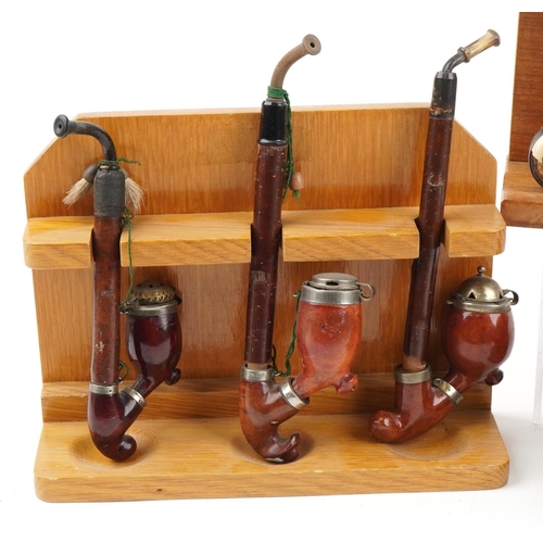 1295 - Nineteen vintage tobacco smoking pipes, some briar, some European, arranged in four pipe racks inclu... 