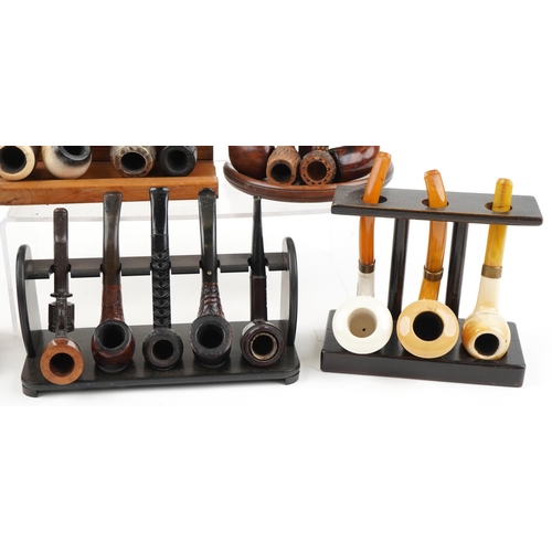 1295 - Nineteen vintage tobacco smoking pipes, some briar, some European, arranged in four pipe racks inclu... 