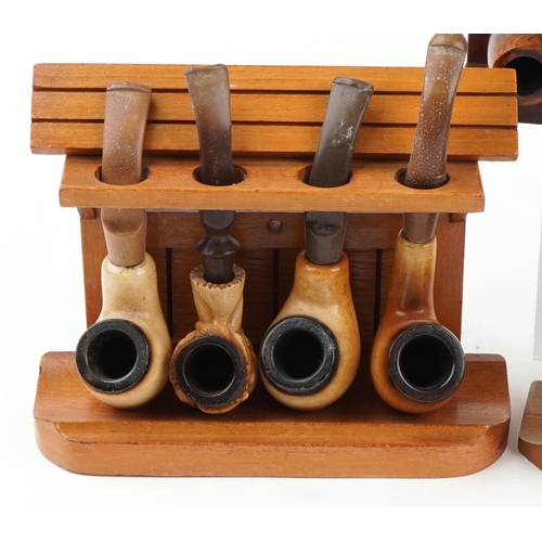 1263 - Twenty three vintage tobacco smoking pipes arranged in five pipe racks, two in the form of a gate, t... 