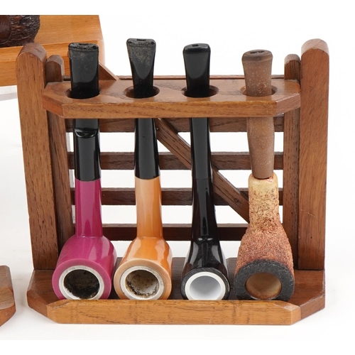 1263 - Twenty three vintage tobacco smoking pipes arranged in five pipe racks, two in the form of a gate, t... 