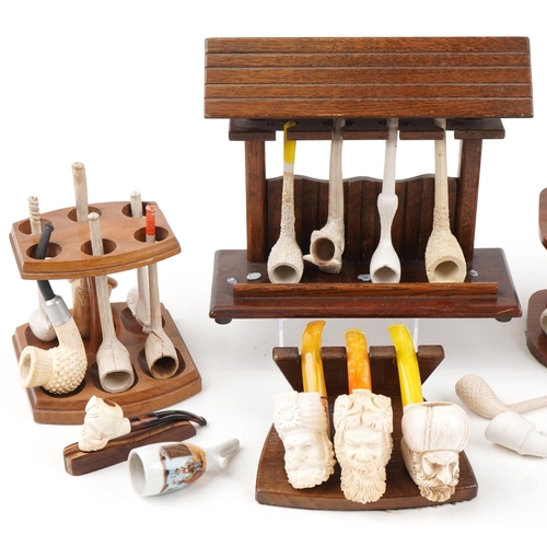 1271 - Antique and later block Meerschaum pipes arranged in five pipe racks including examples with figural... 