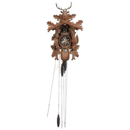 695 - German Black Forest cuckoo clock carved with a deer's head and game having a circular dial with Roma... 