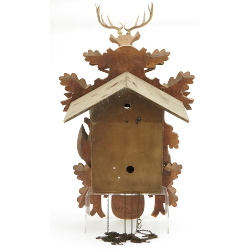 695 - German Black Forest cuckoo clock carved with a deer's head and game having a circular dial with Roma... 