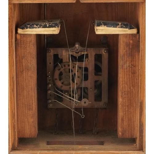 696 - German Black Forest cuckoo clock carved with two figures having circular dial with Arabic numerals, ... 