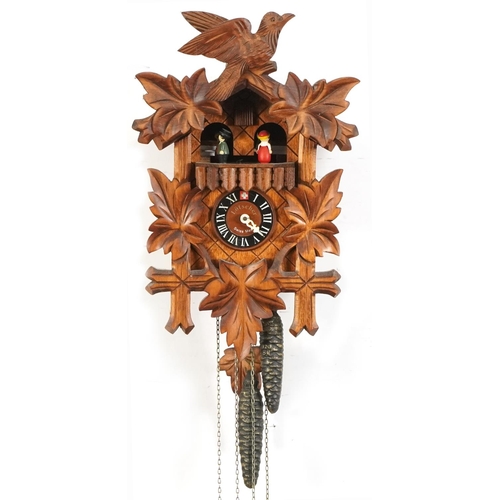 697 - Lotscher, German Black Forest cuckoo clock carved with foliage, having circular dial with Romance mo... 