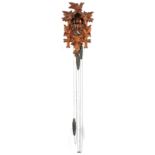 697 - Lotscher, German Black Forest cuckoo clock carved with foliage, having circular dial with Romance mo... 