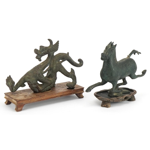 533 - Two Chinese archaic style verdigris cast metal animals including a dragon, each raised on hardwood b... 