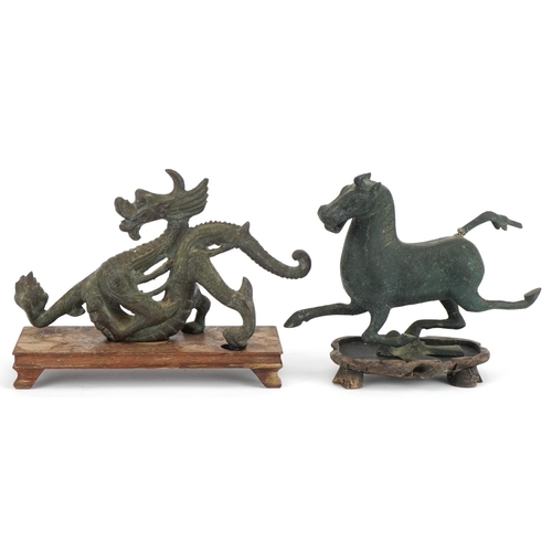 533 - Two Chinese archaic style verdigris cast metal animals including a dragon, each raised on hardwood b... 