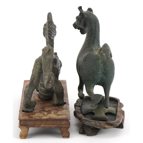 533 - Two Chinese archaic style verdigris cast metal animals including a dragon, each raised on hardwood b... 