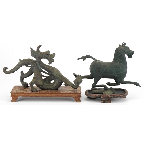 533 - Two Chinese archaic style verdigris cast metal animals including a dragon, each raised on hardwood b... 