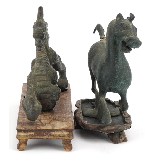 533 - Two Chinese archaic style verdigris cast metal animals including a dragon, each raised on hardwood b... 