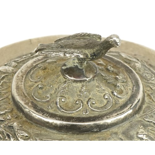 75 - Chinese export unmarked silver four footed bowl and cover profusely embossed with birds amongst cher... 