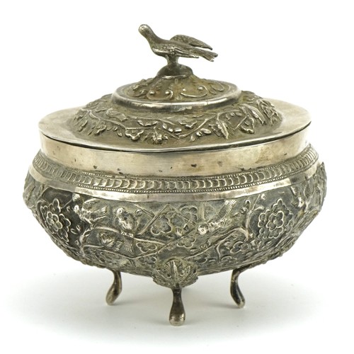 75 - Chinese export unmarked silver four footed bowl and cover profusely embossed with birds amongst cher... 