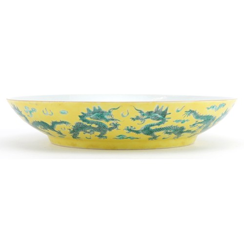 68 - Chinese porcelain yellow ground dish hand painted in green with dragons chasing the flaming pearl am... 