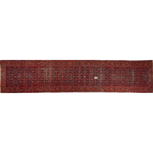 2185 - Rectangular Persian red and blue ground carpet runner having an allover floral repeat central field,... 