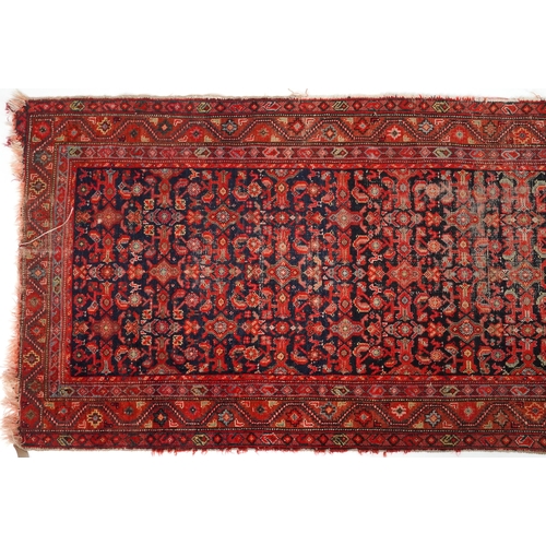 2185 - Rectangular Persian red and blue ground carpet runner having an allover floral repeat central field,... 