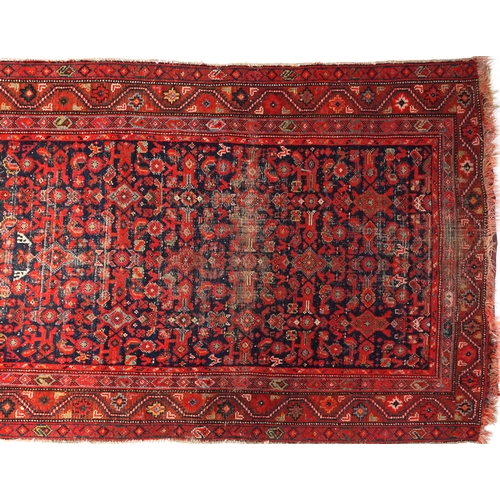 2185 - Rectangular Persian red and blue ground carpet runner having an allover floral repeat central field,... 