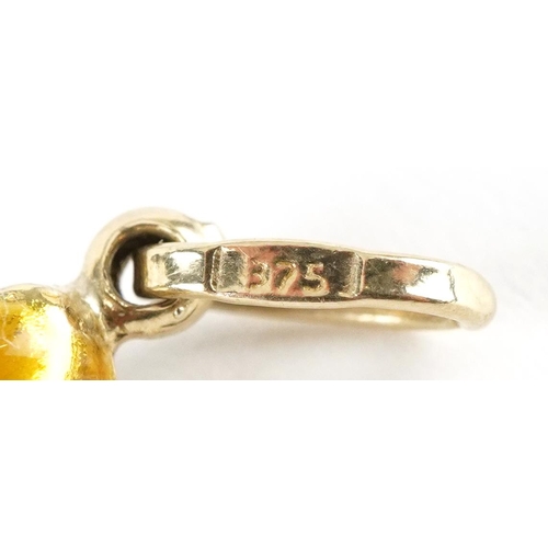 3184 - Three gold and enamel charms comprising 18ct gold Quran, 9ct gold high heeled shoe and unmarked gold... 