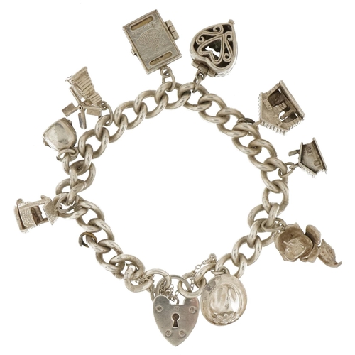 3714 - Silver charm bracelet with a selection of mostly silver charms including enamelled cow bell, wishing... 