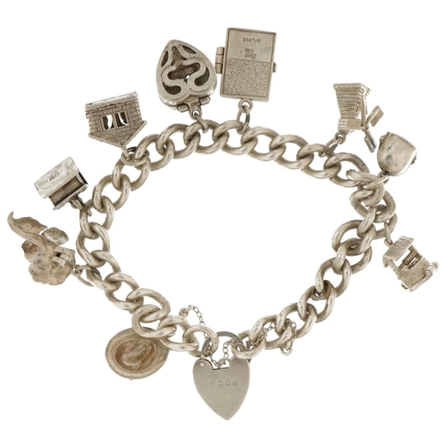 3714 - Silver charm bracelet with a selection of mostly silver charms including enamelled cow bell, wishing... 