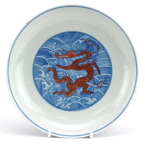 673 - Chinese blue and white with iron red porcelain shallow dish hand painted with dragons amongst crashi... 