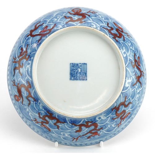 673 - Chinese blue and white with iron red porcelain shallow dish hand painted with dragons amongst crashi... 