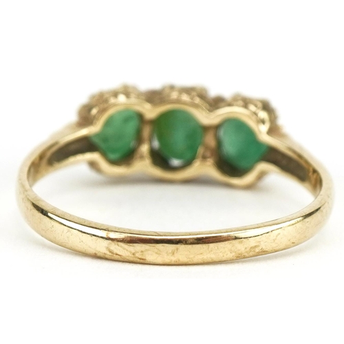 3185 - 9ct gold emerald three stone ring with engraved shoulders, size N, 2.1g