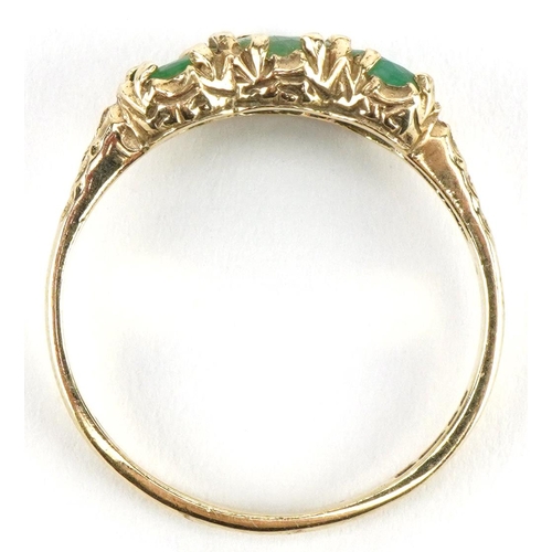 3185 - 9ct gold emerald three stone ring with engraved shoulders, size N, 2.1g