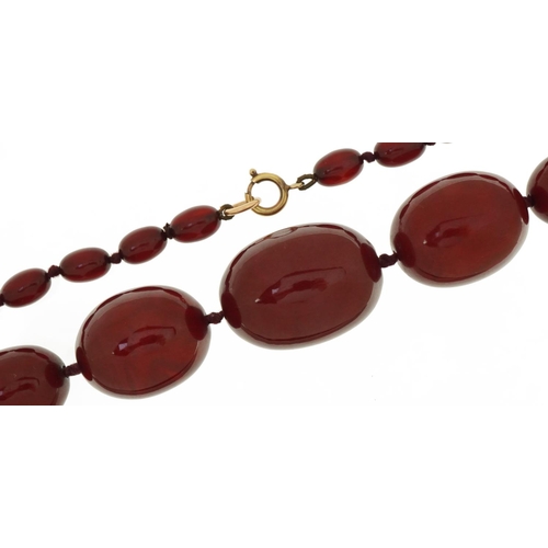 3046 - Large cherry amber graduated bead necklace, the largest bead approximately 35mm x 26mm in diameter, ... 