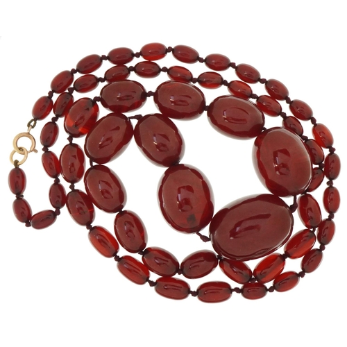 3046 - Large cherry amber graduated bead necklace, the largest bead approximately 35mm x 26mm in diameter, ... 