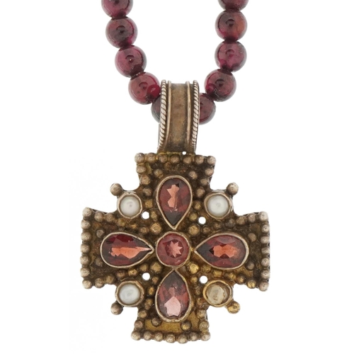 3500 - Silver gilt garnet and seed pearl pendant on a garnet bead necklace, 3.2cm high and 48cm in length, ... 