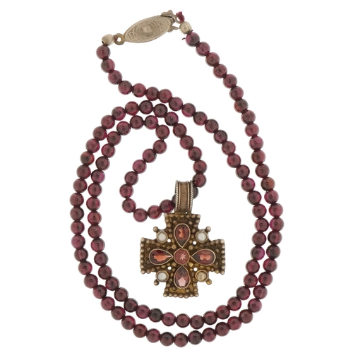 3500 - Silver gilt garnet and seed pearl pendant on a garnet bead necklace, 3.2cm high and 48cm in length, ... 