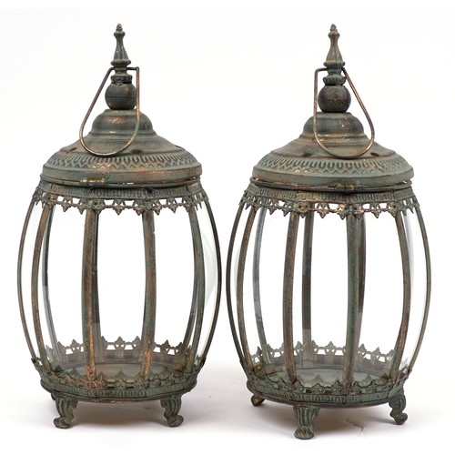 2560 - Pair of bronzed hanging lanterns with glass panels on paw feet, each 48.5cm high