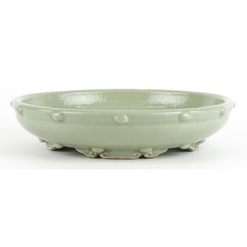 138 - Chinese porcelain four footed censer having a celadon glaze, 23cm in diameter