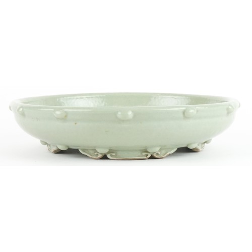 138 - Chinese porcelain four footed censer having a celadon glaze, 23cm in diameter