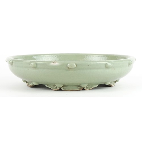 138 - Chinese porcelain four footed censer having a celadon glaze, 23cm in diameter