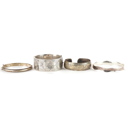 3588 - Three silver bangles and a white metal floral bangle, total weight 74.0g